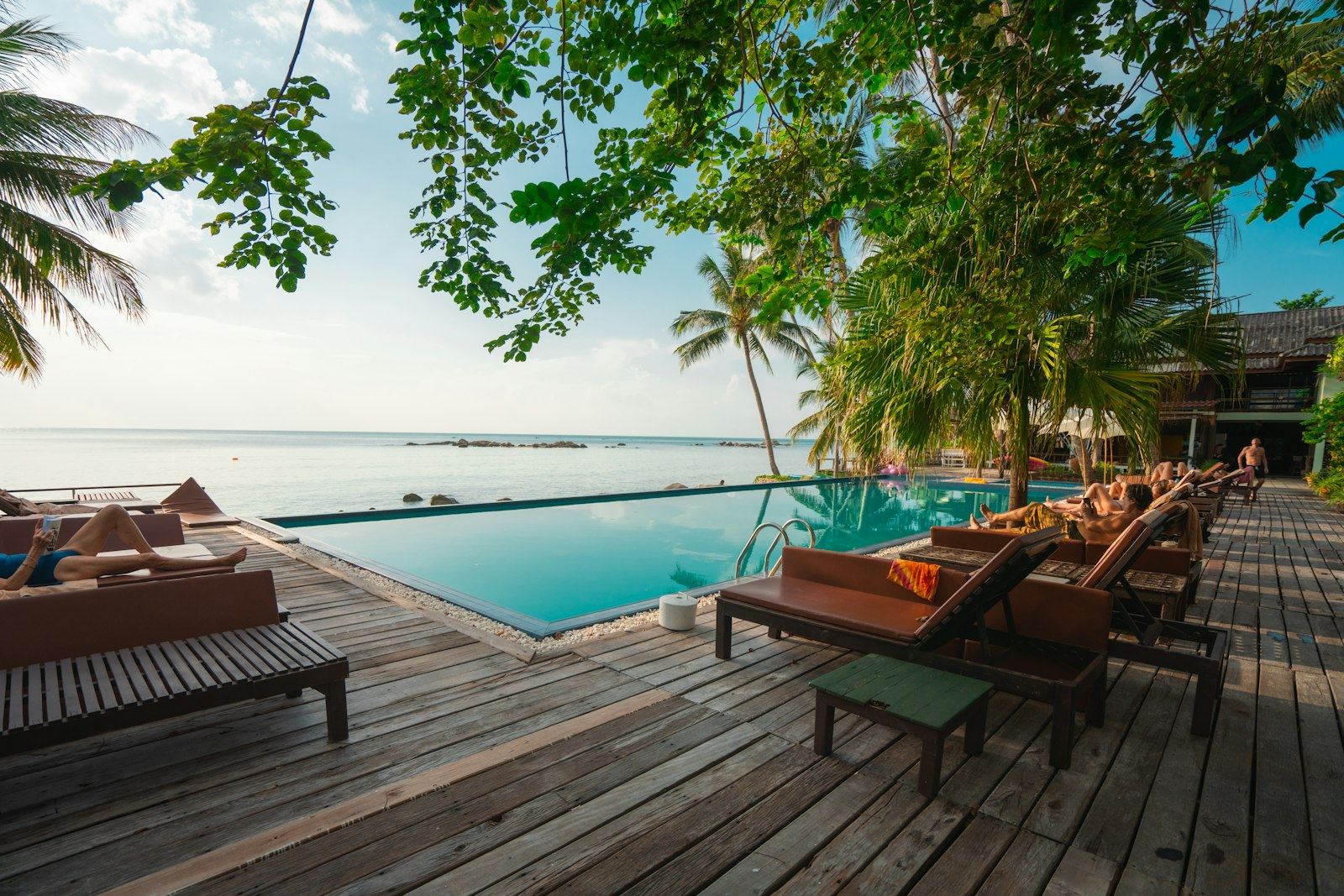 Daybeds und Pool in einem Beach Club auf Bali